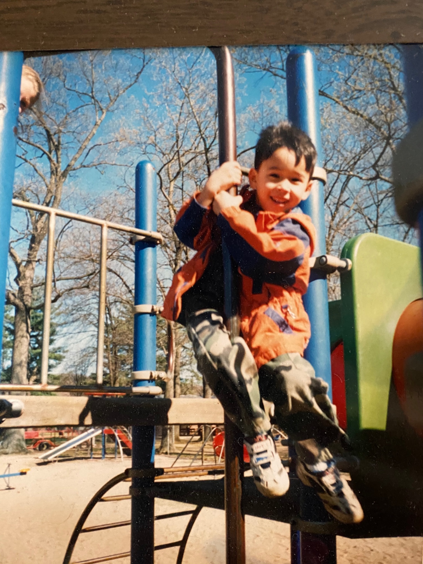 Young Zack Forte climbing on a playground